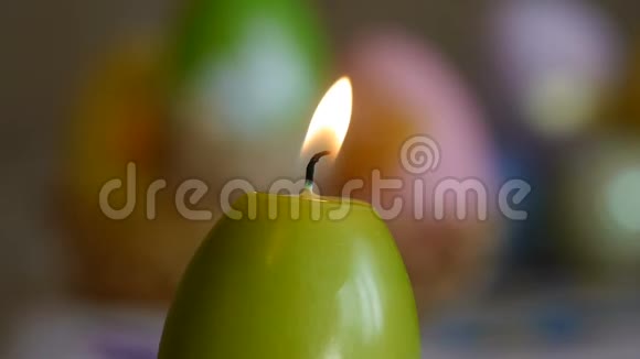 用复活节彩蛋做成的蜡烛燃烧蜡烛绿色的蜡烛从空中熄灭视频的预览图