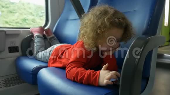 火车上的孩子看智能手机视频的预览图