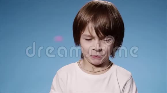 可爱的小男孩被饼干和微笑吓到的超慢动作蓝色视频的预览图