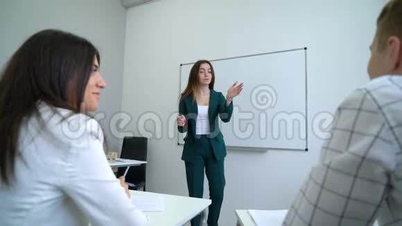 白板附近的年轻白种人教师在教室里辅导大学生视频的预览图