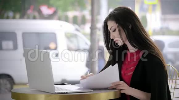年轻的女记者在城市道路交通的背景下写文章做笔记在笔记本电脑上工作视频的预览图