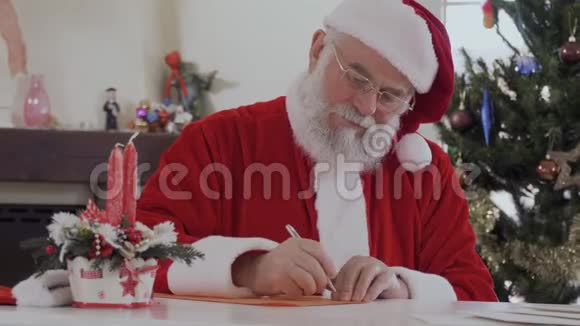 圣诞老人坐在桌边写信视频的预览图
