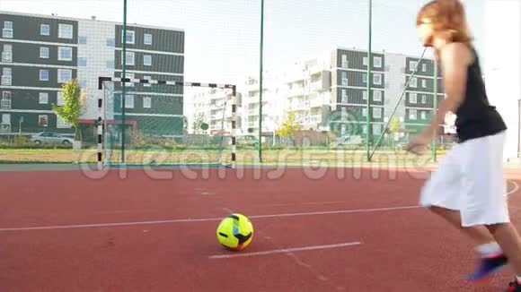 一个小男孩进球踢球他在户外踢足球很有趣视频的预览图