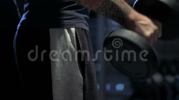 一个手拿哑铃弯曲手臂的家伙在健身房锻炼视频的预览图
