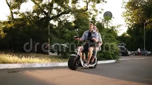 一对快乐的夫妇在夏天骑电动自行车在街上美丽的女孩和她的男朋友享受他们的时光视频的预览图