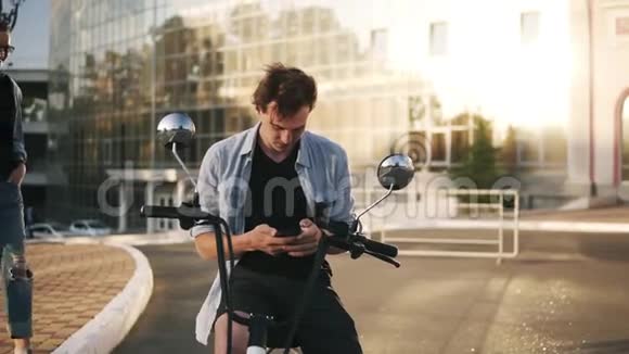 年轻夫妇那个女孩在猜谁和她男朋友玩游戏有魅力的男人坐在自行车上城市街道视频的预览图