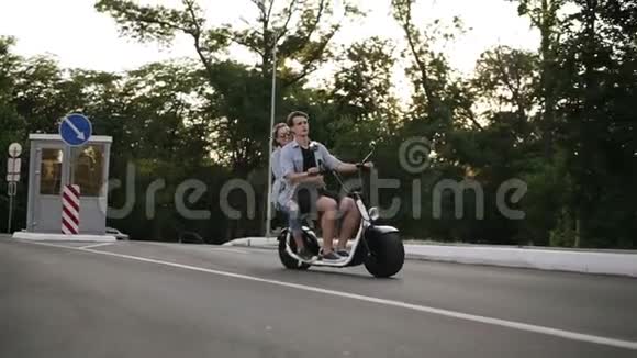一对夫妇骑自行车玩得开心的侧面景色美丽的年轻女人和男人在城市里开车自由视频的预览图