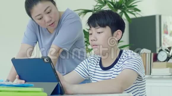 亚洲母亲正在控制她的儿子做家庭作业视频的预览图
