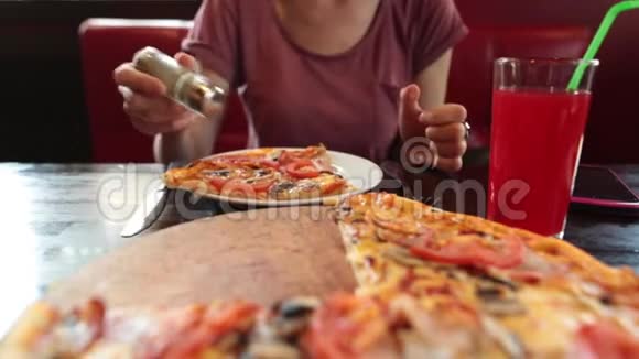 随便的女孩吃一块披萨用叉子和刀子吃坐在餐馆里视频的预览图