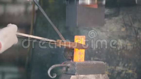 铁匠在工作时用电锤在铁砧上制作正确的红色热钢形状工艺视频的预览图