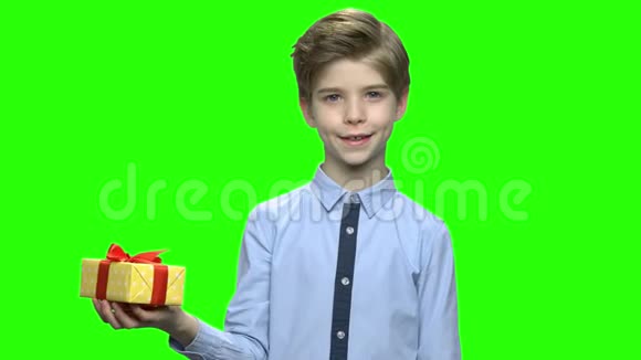 英俊的孩子拿着红色丝带的黄色礼品盒视频的预览图