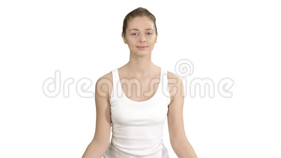 年轻女子坐在莲花的姿势上闭着眼睛沉思着白色的背景视频的预览图