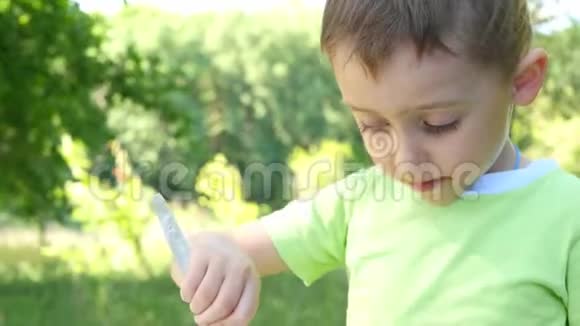 特写一个孩子吃什什烤肉串烧烤特写的自然背景摄像机从儿童手中移动视频的预览图