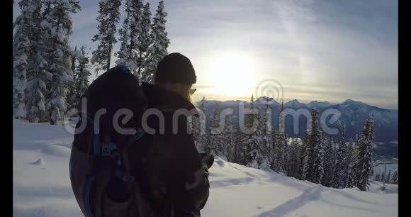 带背包的女人用她的手机在雪山4k视频的预览图
