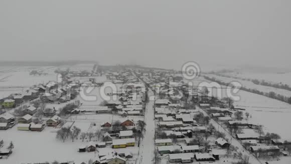 乌克兰村庄的空中景色冬天下雪平稳飞行返回视频的预览图