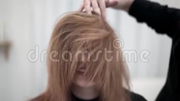 理发师理发后抚摸她的年轻客户的红头发视频的预览图
