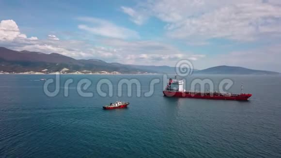 红色油轮船在水上的鸟瞰图拖船靠近港口视频的预览图