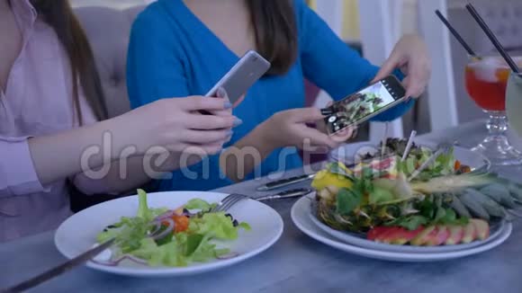 在健康的午餐期间女朋友在智能手机上为减肥拍照视频的预览图
