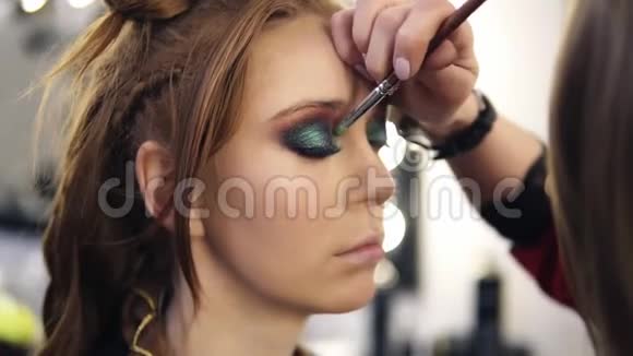 化妆师将一些彩色阴影应用在模特眼皮上侧视图视频的预览图