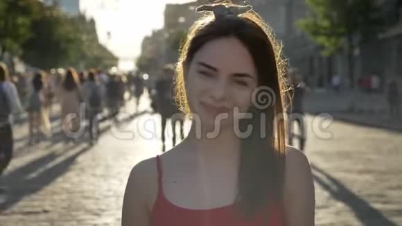 年轻美丽的女人的肖像姜发站在街上看着镜头微笑着人们走着视频的预览图