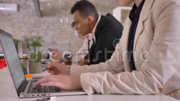 混合种族的商业团队在现代办公室工作写在纸上黑人看着笔记本电脑相机移动视频的预览图