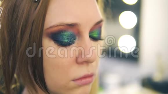 化妆师用刷子把粉底涂在年轻女人脸上涂在鼻子和脸颊上侧视图视频的预览图