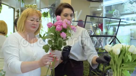 花商和助理用玫瑰和郁金香制作花束视频的预览图