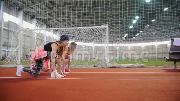 两名年轻的运动员开始在运动场上奔跑视频的预览图