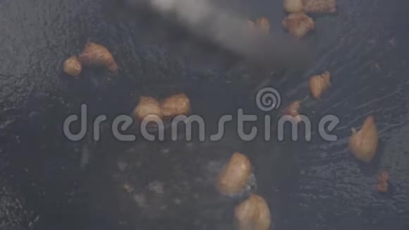 噼里啪啦在大煎锅里翻炒特写肉片用油煎慢动作视频的预览图