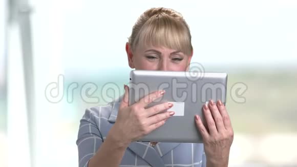 成熟的女人使用迪塔尔平板电脑视频的预览图