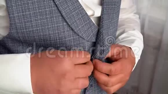 穿西装的时髦男人在夹克上扣扣子视频的预览图
