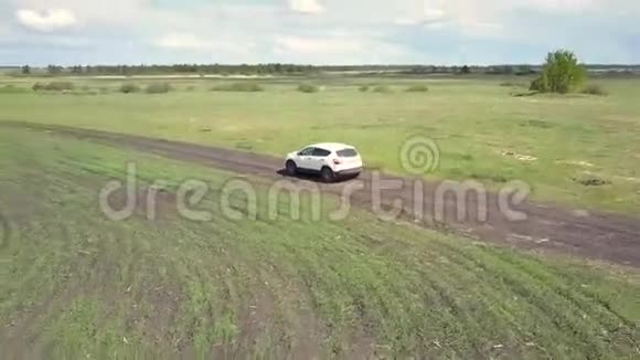 空中观景车沿着蜿蜒的道路行驶在田野之间视频的预览图