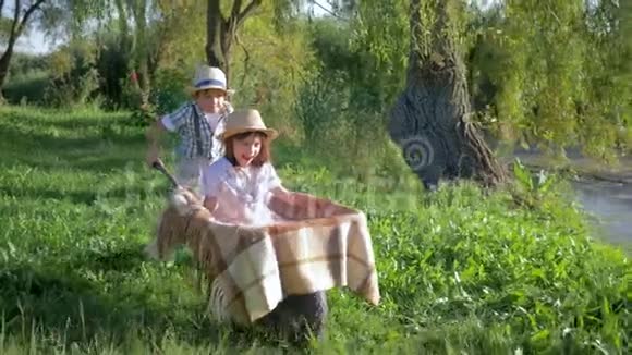 娱乐户外小男孩骑着手推车在湖边的乡村视频的预览图