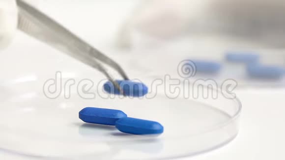 实验室科学家在培养皿中分拣蓝色药丸视频的预览图
