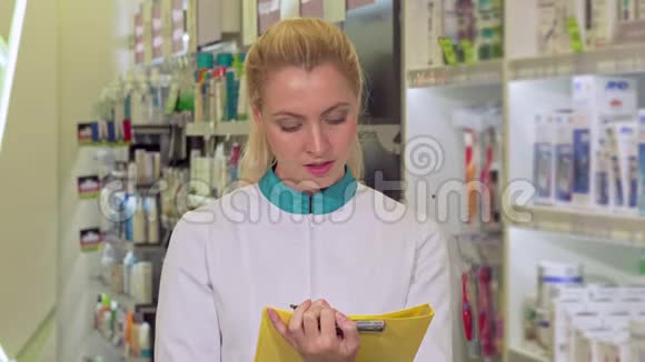 开朗的女药剂师填写文件在药店工作视频的预览图