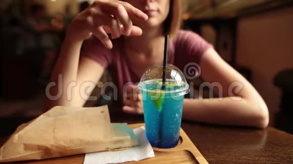 在咖啡馆里喝着冰蓝色柠檬水的美女视频的预览图