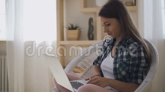 漂亮的女人从事博客坐在家里的笔记本电脑视频的预览图