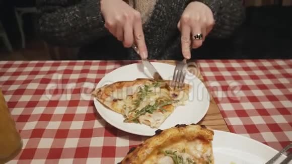 在餐馆里用刀叉吃披萨的饿女人视频的预览图