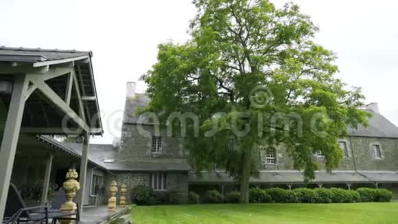 有绿色草坪和树木的庄园住宅庭院行动绿树点缀着老石庄园的庭院国家视频的预览图