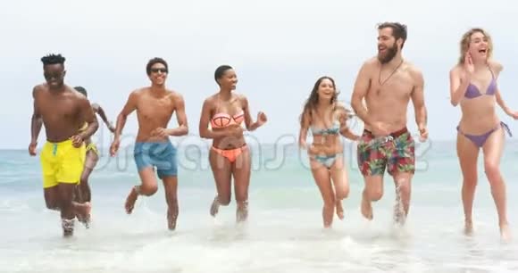一群混血朋友一起在海滩上跑步4k视频的预览图