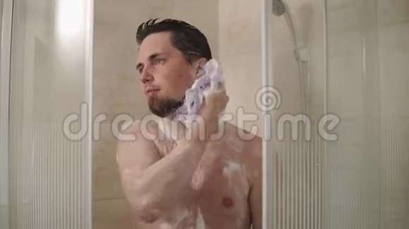 一个年轻人用丝瓜和肥皂洗澡的肖像视频的预览图