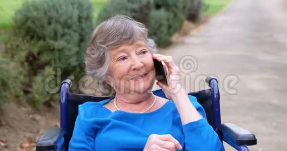 轮椅上的老年妇女在讲手机视频的预览图