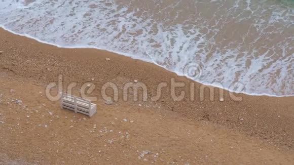 一张孤独的白色木凳矗立在沙滩上视频的预览图