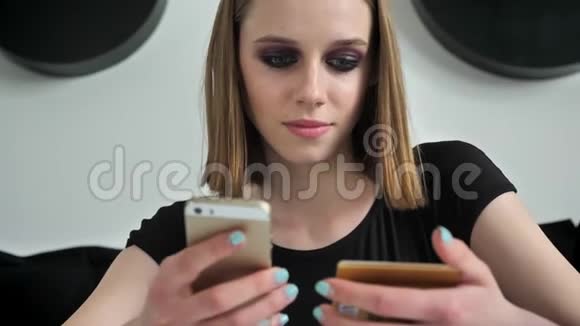 年轻美丽的女人浓妆艳抹的打着电话拿着卡片微笑着黑白咖啡馆背景视频的预览图