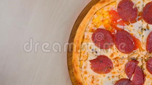 一半的意大利腊肠披萨放在桌上的木板上特写俯视图视频的预览图