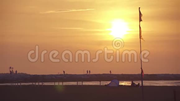 日出在海边在人们经过的卵石面前视频的预览图
