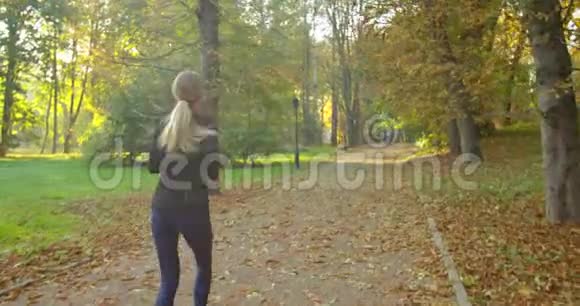 女人在阳光明媚的城市公园里奔跑晨光视频的预览图