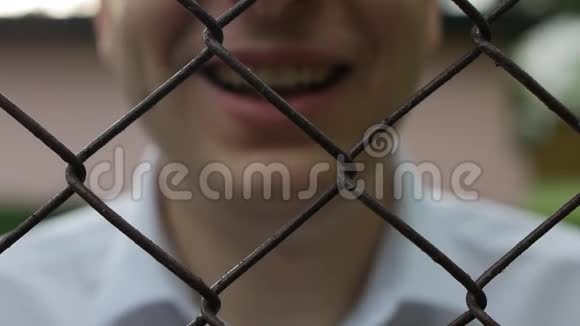 一个穿着白色衬衫的人在网后用透明胶带盖住他的嘴不透露信息自由视频的预览图