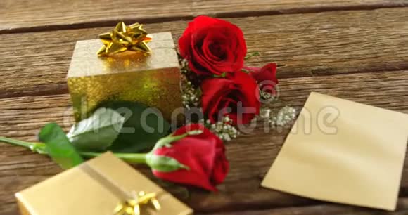 4k木制表面的红玫瑰礼品盒和卡片视频的预览图
