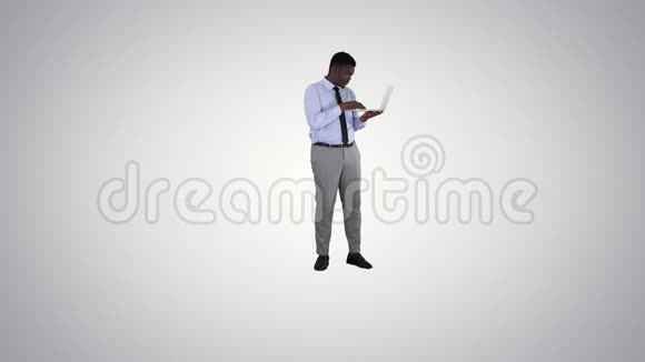 美国黑人商人在梯度背景下使用笔记本电脑视频的预览图